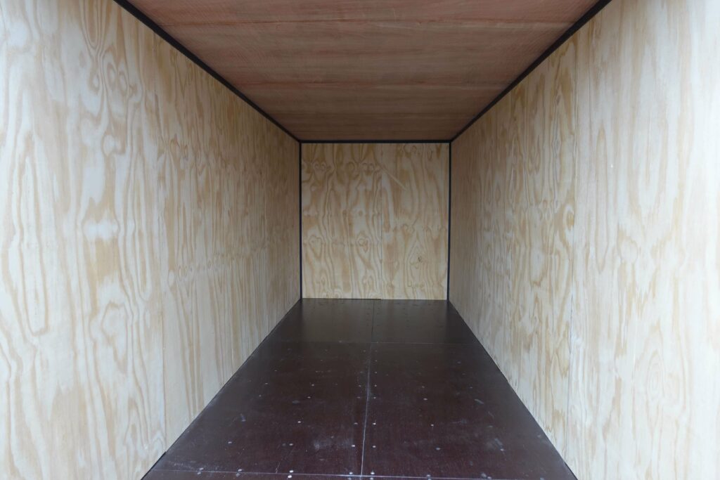 inside of a shipping container lined with ply wood